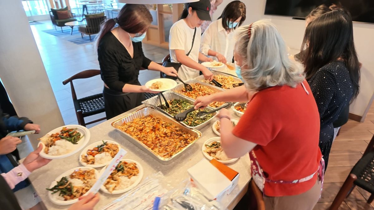 聚会后大家排队取餐、边吃边聊